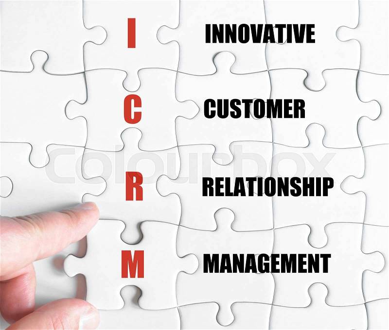 Hand of a business man completing the puzzle with the last missing piece.Concept image of Business Acronym ICRM as Innovative Customer Relationship Management, stock photo