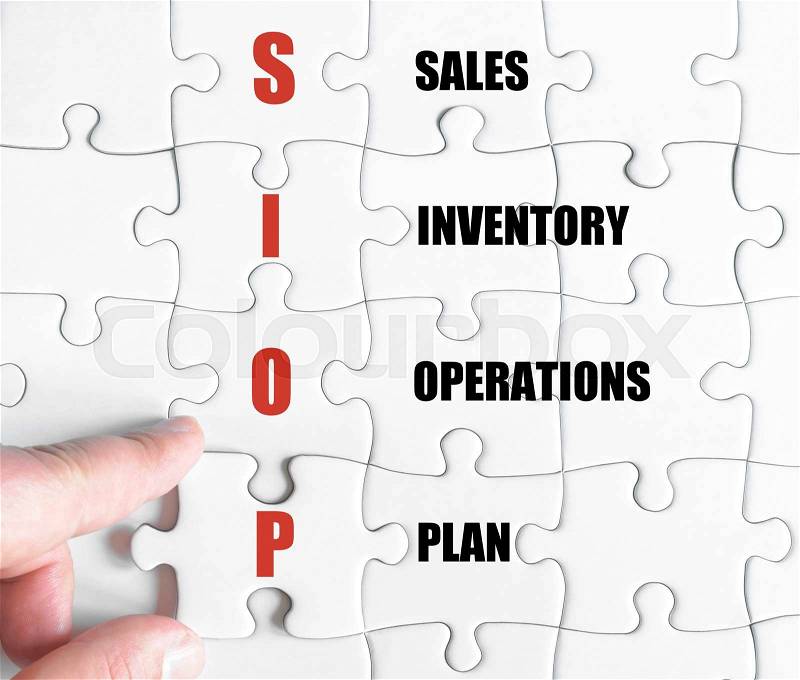 Hand of a business man completing the puzzle with the last missing piece.Concept image of Business Acronym SIOP as Sales Inventory Operations Plan, stock photo