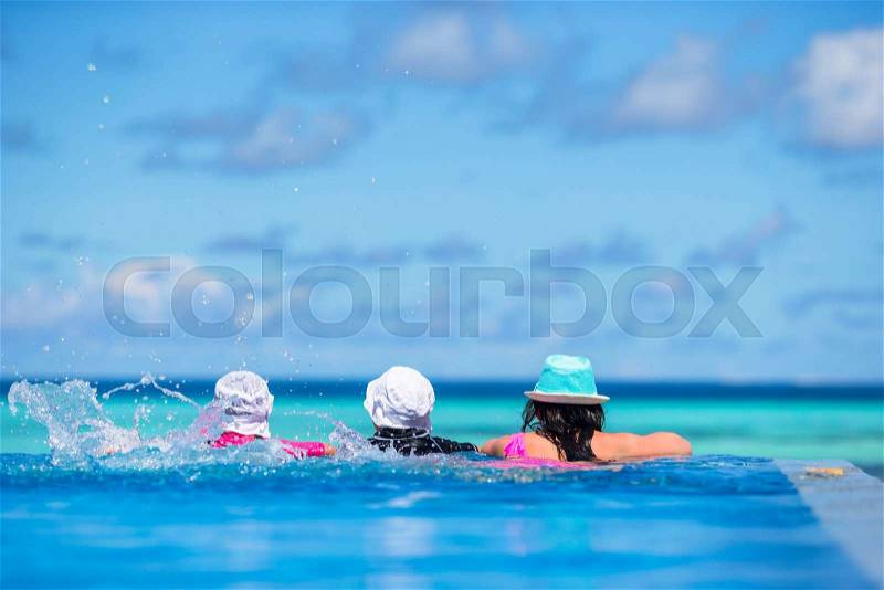 Young beautiful woman and girls enjoying the luxurious quiet swimmingpool, stock photo