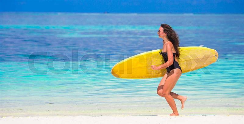 Happy shapely surf woman at white beach with yellow surfboard, stock photo
