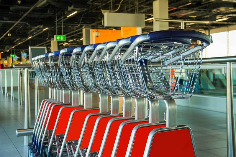 Row of luggage carts in hall of the airport, stock photo
