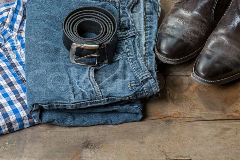Jeans, Belt and leather boots, on a rustic wooden background, stock photo