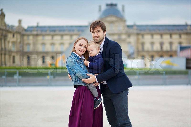 Happy family of three in Paris near Louvre, stock photo