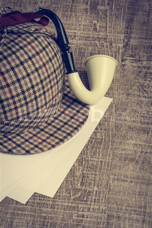 Deerstalker or Sherlock Hat and Tobacco pipe on Old Wooden table, stock photo