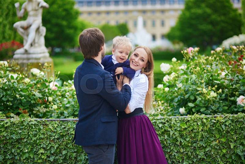 Happy family of three in the beautiful garden of Palais Royal in Paris, stock photo