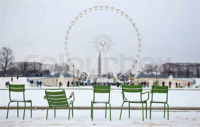 Winter in Paris. Chairs in Tuileries garden and snow, stock photo
