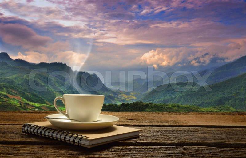 Morning cup of coffee with mountain background at sunrise, stock photo