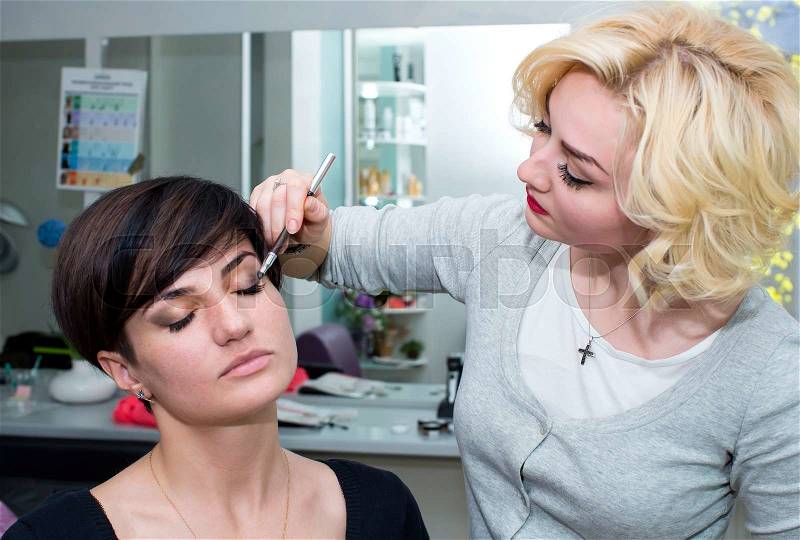 Make-up artist in the studio doing makeup beauty girl, stock photo