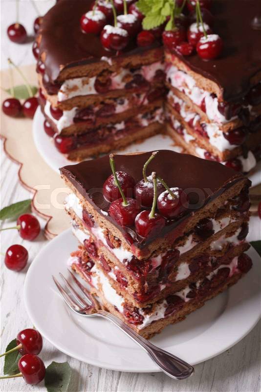Tasty cherry cake with chocolate and cream on a plate close-up. vertical top view\, stock photo