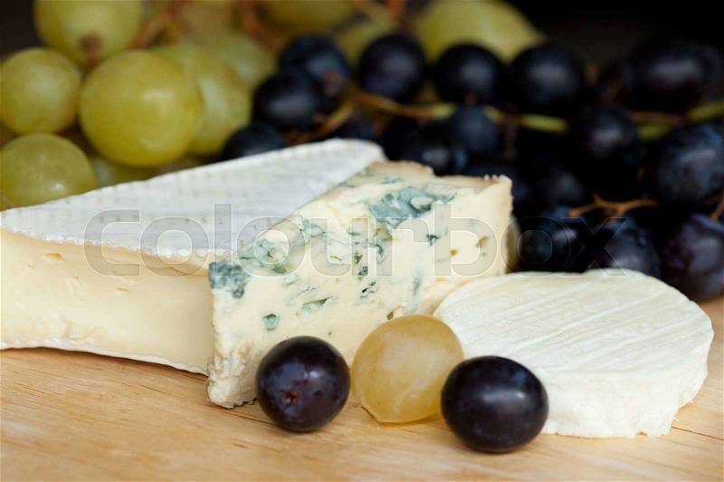 Three types of cheese and fresh grapes, stock photo