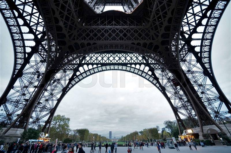 Paris, France - October 3, 2011: Tourists walking on the bottom of the Eiffel Tower. Eiffel Tower is the most popular attraction of Paris, the most visited city in the world, stock photo