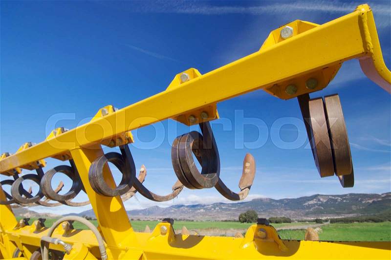 Tool for agricultural tillage yellow and blue sky, stock photo