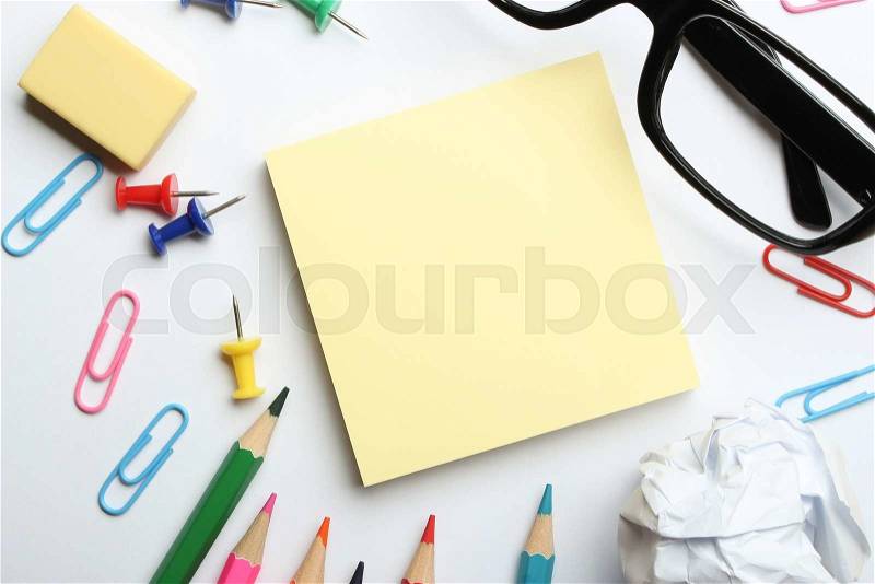 School supplies and blank sticky note block on the white paper background, stock photo