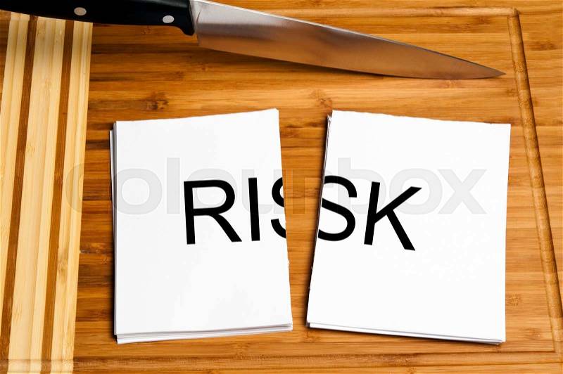 Knife cut paper with risk word, stock photo