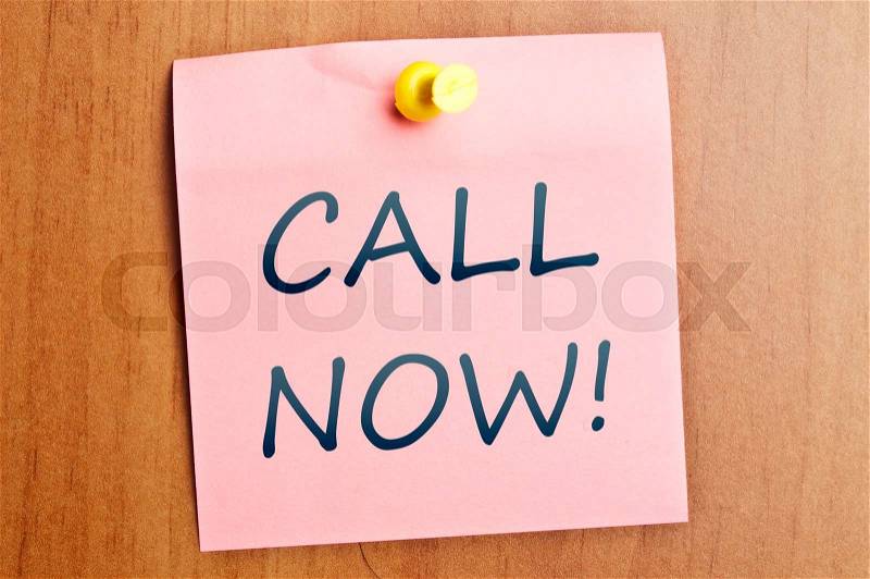 Call now post it on wooden wall, stock photo