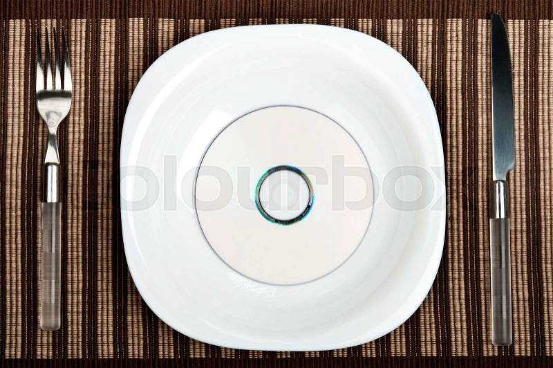 Cd on plate with fork and knife, stock photo