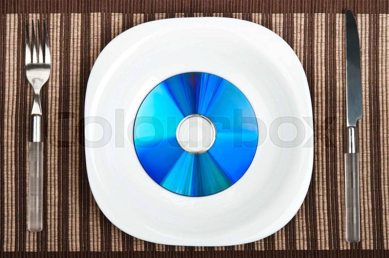 Cd on plate with fork and knife, stock photo