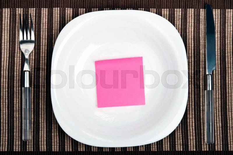 Post-it on plate with fork and knife, stock photo