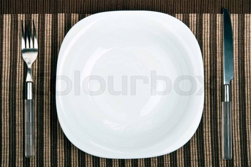 Empty plate with fork and knife, stock photo