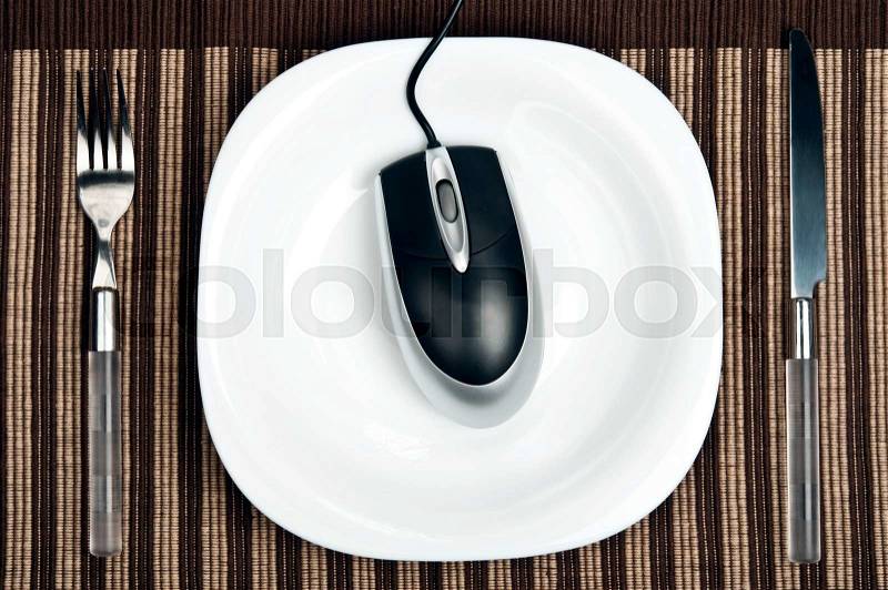 Pc mouse on plate with fork and knife, stock photo
