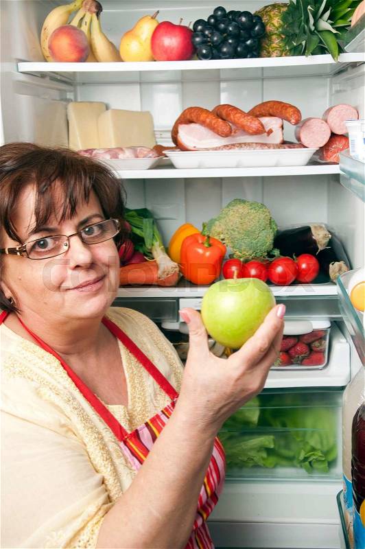 Refrigerator close up with mature woman, stock photo