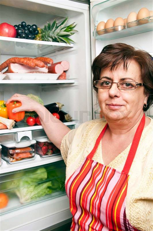 Refrigerator close up with mature woman, stock photo