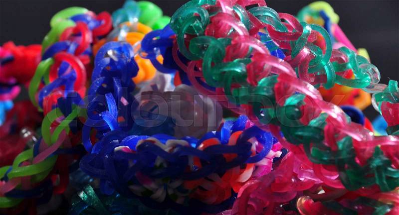 Colorful background rainbow colors rubber bands loom bracelets on black background, stock photo