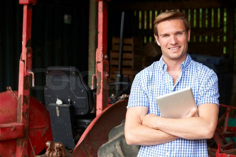 Portrait Of Farmer With Old Fashioned Tractor And Digital Tablet, stock photo