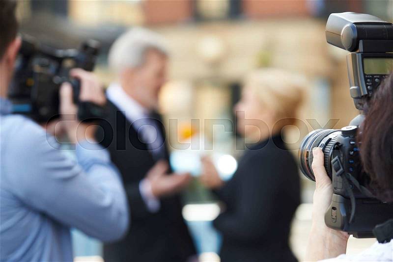 Photographer Taking Pictures Of Female Journalist Interviewing Businessman, stock photo