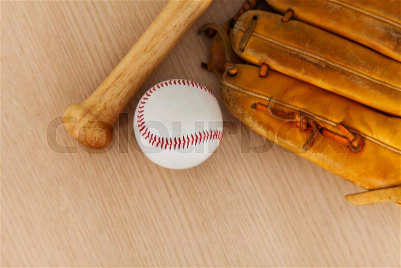 Baseball bat with ball and baseball glove on wood background, stock photo