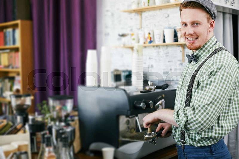 Young barista working in cafe, stock photo