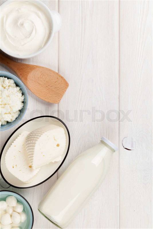 Dairy products on wooden table. Sour cream, milk, cheese and yogurt. Top view with copy space, stock photo