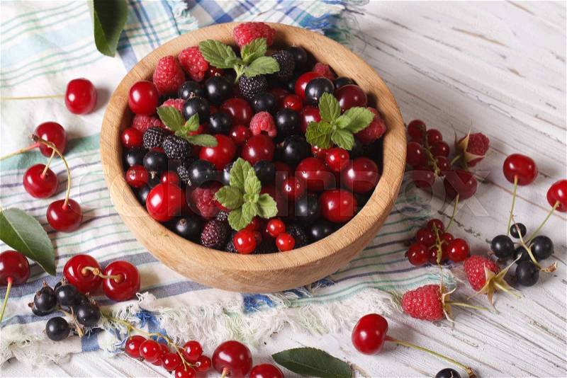 Berry mix in a wooden bowl on the table close-up. horizontal , stock photo