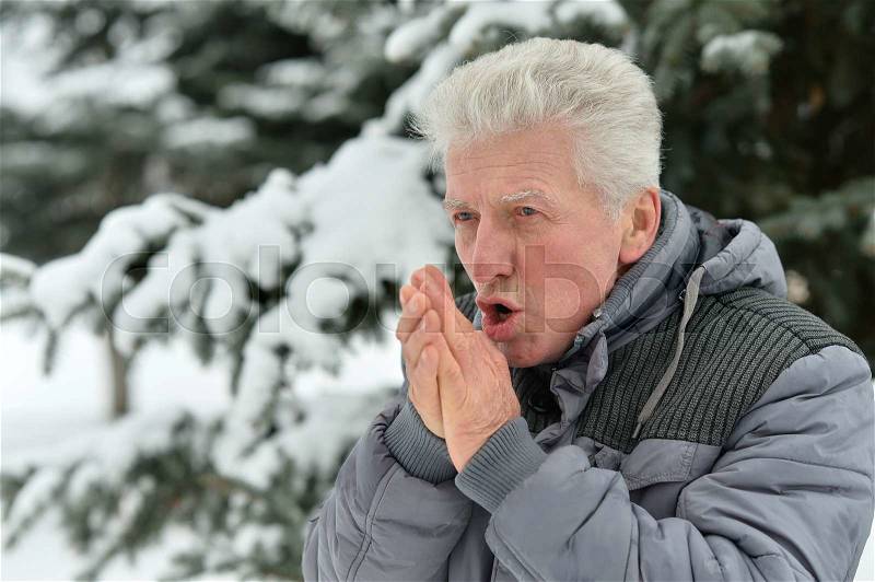 Senior man standing outdoor in winter with thumbs up, stock photo