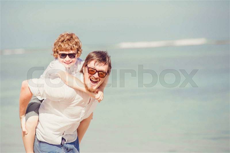 Happy father father with beard and red haired son wearing sunglasses having happy summer time at a sunny day on vacation. Family, hapiness, travel concept, stock photo