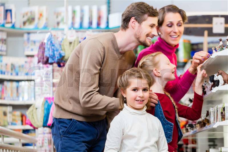Family buying toys in toy store in toy store standing on a shelf choosing figures, stock photo