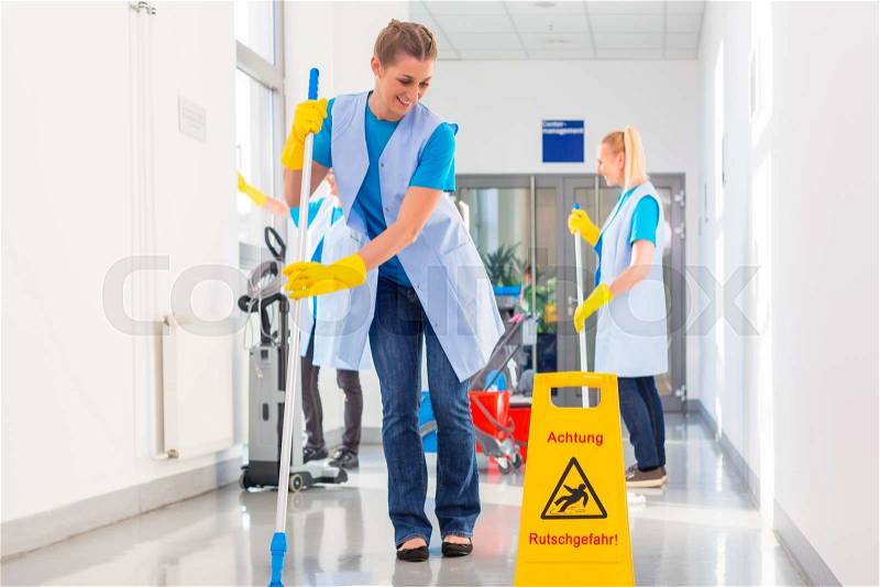Commercial cleaning brigade working mopping the floor, stock photo