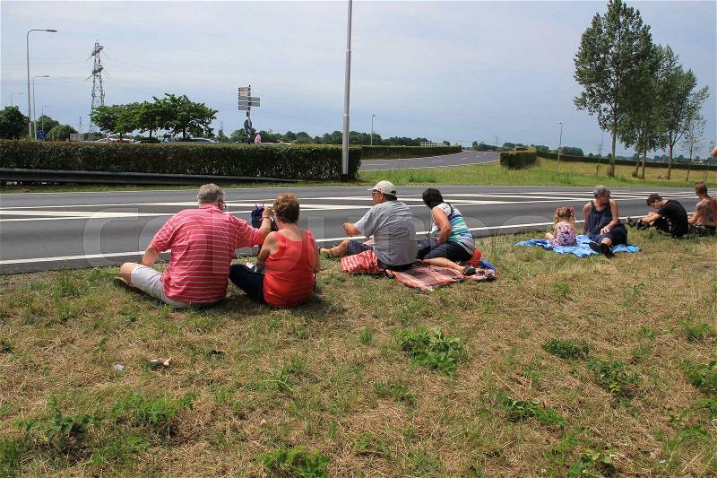 The people on the blanket are waiting along the route at the cyclists of the Tour de France in the summer, stock photo