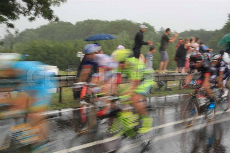The audience support the cyclists of the Tour de France in the bad wheater, it's raining cats and dogs, in the summer, stock photo