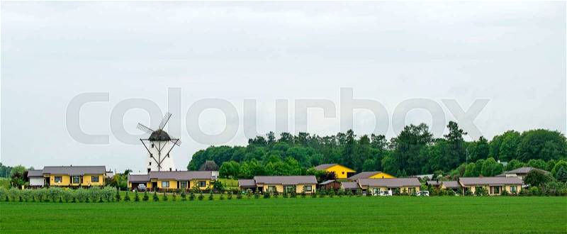 Modern village. Traditional windmill and houses, stock photo