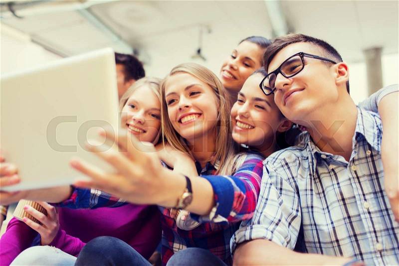 Education, high school, technology and people concept - group of smiling students with tablet pc computer taking photo or video indoors, stock photo