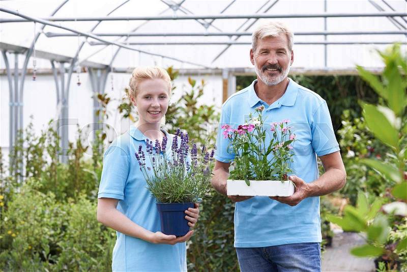 Portrait Of Staff At Garden Center Holding Plants, stock photo