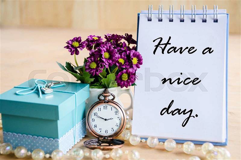 Have a nice day. Open diary, pocket watch, gift box and flower on wooden backgroudn, stock photo