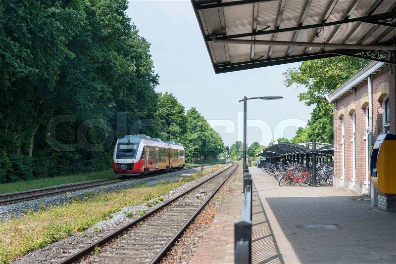 DELDEN,HOLLAND-JULY 4,2015: red train in holland crossing station of the city delden,Delden is the smallest station in the east part of delden still in use, stock photo