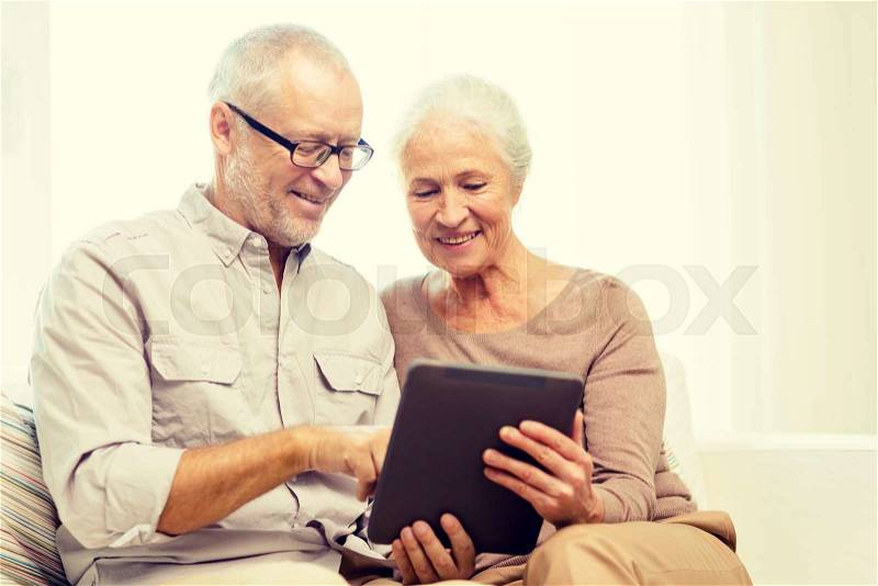 Family, technology, age and people concept - happy senior couple with tablet pc computer at home, stock photo