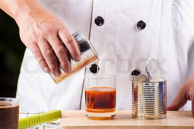 Pouring Can milk in to the cup of Tea, stock photo