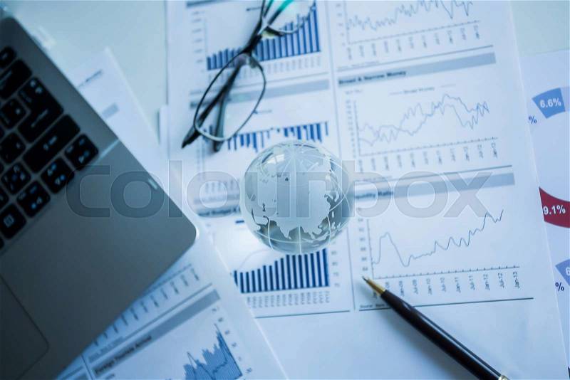 Businessman checking reported profits on the paper, stock photo