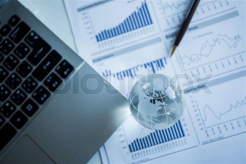 Businessman checking reported profits on the paper, stock photo