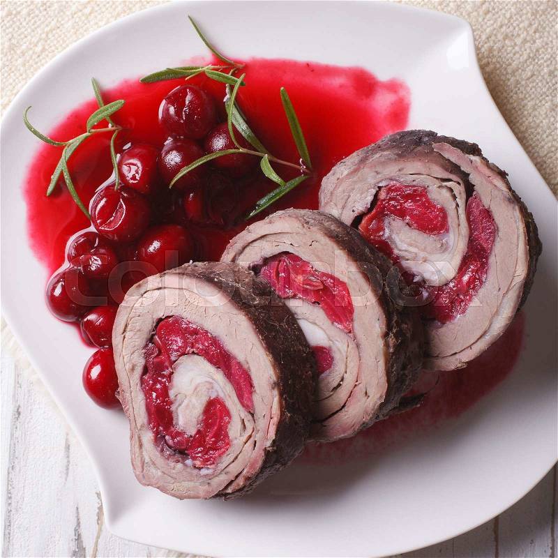 Meat stuffed with cherries and sauce on a plate close-up. view from above , stock photo