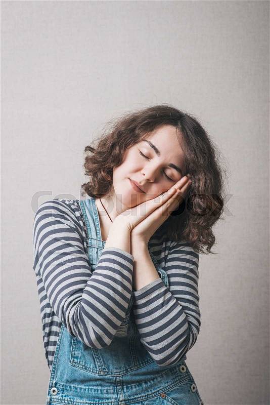 A woman wants to sleep. Gray background, stock photo